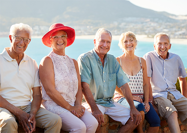 5 Freunde junge Senioren, die im Urlaub vor einem See posieren